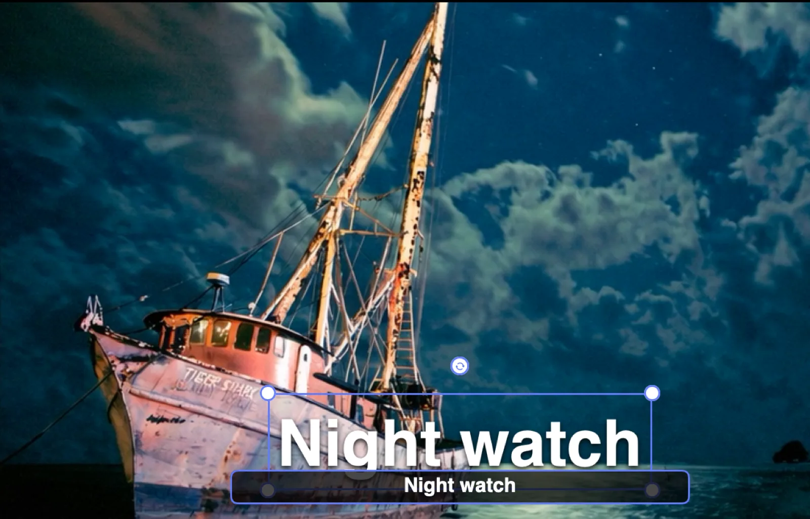 Typing a caption directly on the canvas: over the moonlit fishing boat, the fully styled words “Night watch” sit inside a selection box with corner handles and a rotation knob, while a floating dark input chip just below shows the same text being edited live.