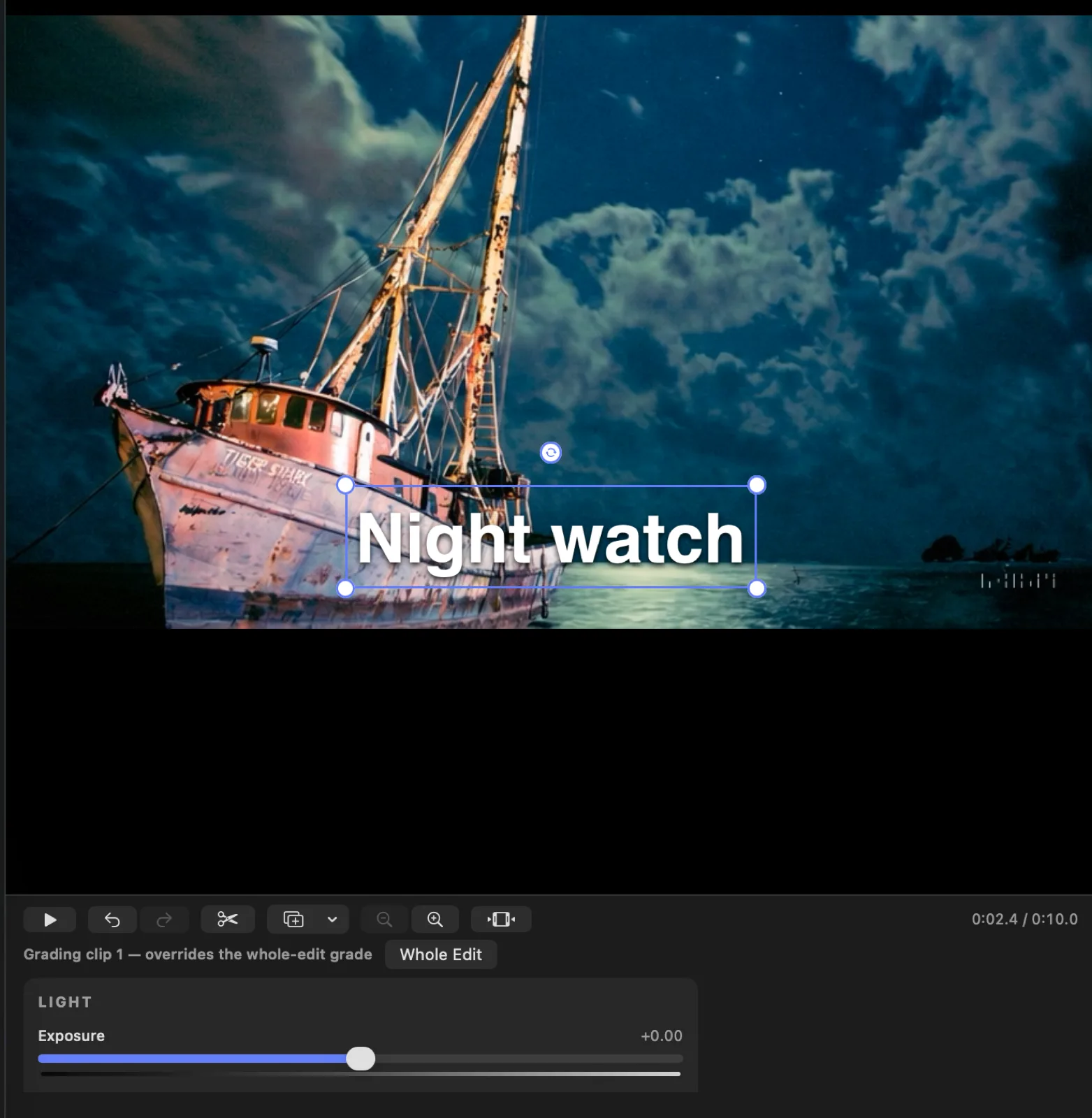 The grade tray open where the timeline normally sits: it reads “Grading clip 1 — overrides the whole-edit grade” beside a Whole Edit button, with the same LIGHT and Exposure controls used on photos, over the captioned boat footage.